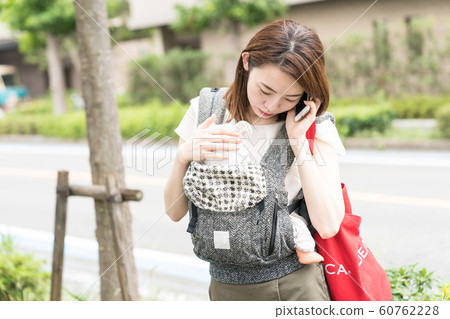 一個女人抱著一個嬰兒，打電話 60762228