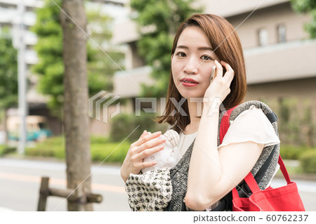 A woman holding a baby and calling 60762237