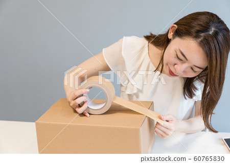 Woman packing cardboard 60765830