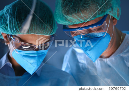 Male and female plastic surgeon in blue face mask Male and female plastic surgeon in blue face mask 60769702