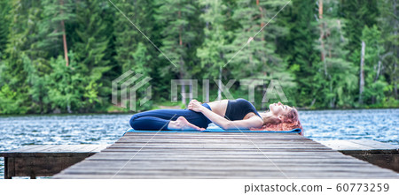 Young  girl  practicing yoga in the nature on the 60773259