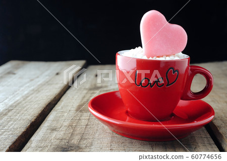 Pink heart shape on red coffee cup with wood table background ,vintage love concept. Pink heart shape on red coffee cup with wood table background ,vintage love concept. 60774656