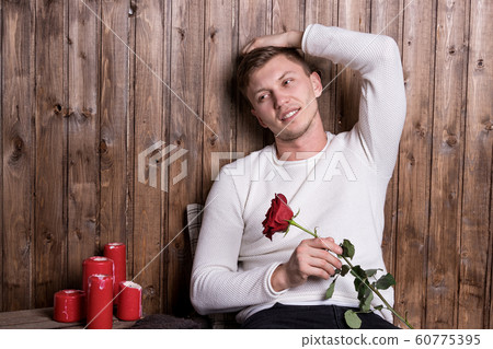Young handsome man with a rose in his hands 60775395
