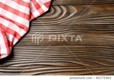 Red checkered napkin on brown wooden kitchen table 60775903