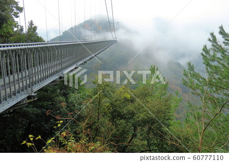 Suspension bridge disappearing in the clouds 60777110