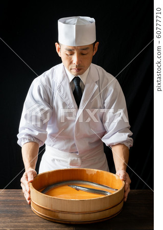 Itamae with a tub containing eel 60777710