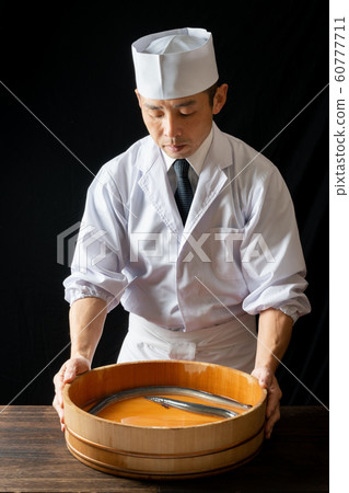 Itamae with a tub containing eel Itamae with a tub containing eel 60777711