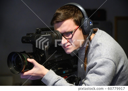Cameraman using professional digital video camera. Cameraman using professional digital video camera. 60779917