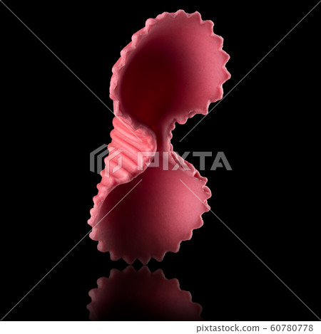 Macro photo of pink farfalle pasta isolated on black with clipping path Macro photo of pink farfalle pasta isolated on black with clipping path 60780778