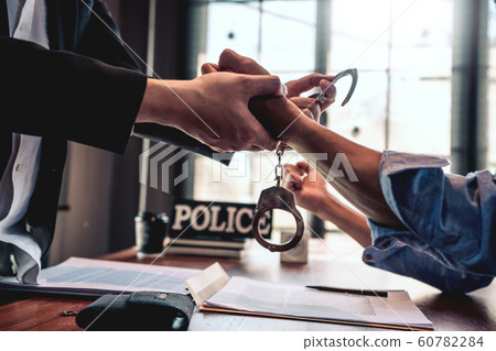 suspect with handcuffs being interviewed in suspect with handcuffs being interviewed in 60782284