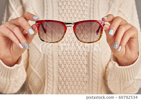 Manicure in blue colors. Woman fingers holding 60782534