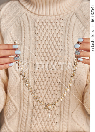 Beautiful necklace with pearls in a female hands. Beautiful necklace with pearls in a female hands. 60782543