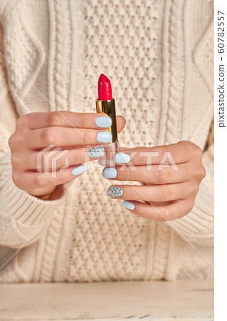 Red lipstick in female hands on a background of a Red lipstick in female hands on a background of a 60782557