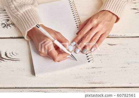 Beautiful female hands write in notebook. 60782561