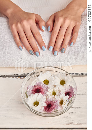 Beautiful well-groomed female hands on a white Beautiful well-groomed female hands on a white 60782571
