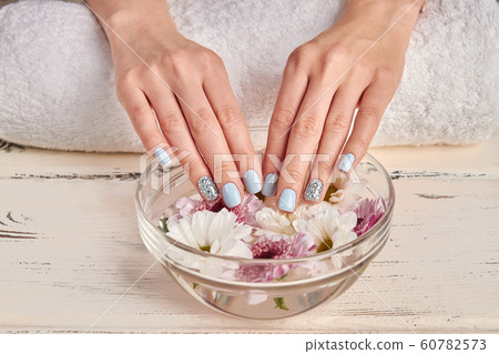 Spa for hands. Delicate flowers in a glass bowl. 60782573
