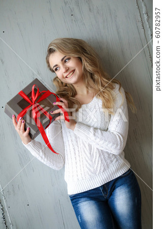 Woman holds a gift in a box on a birthday or new year Woman holds a gift in a box on a birthday or new year 60782957