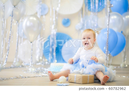 Celebrating the birthday of a girl of age 1 year. Girl in a blue skirt 60782962