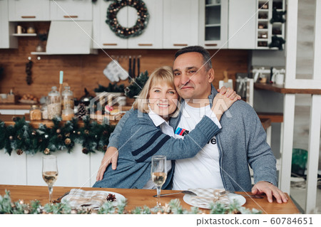 Happy beautiful adult woman hugging her husband Happy beautiful adult woman hugging her husband 60784651