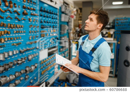 Plumber at showcase with valves and pipe adapters 60786688