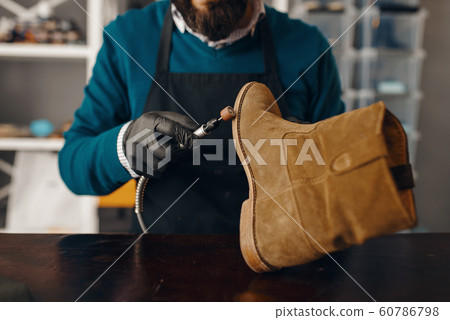 Shoemaker sharpens the shoe sole, footwear repair Shoemaker sharpens the shoe sole, footwear repair 60786798