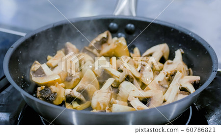 Champignon mushrooms frying and sizzling in pan Champignon mushrooms frying and sizzling in pan 60786821