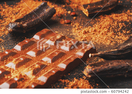 Carob fruit on a black background with chocolate Carob fruit on a black background with chocolate 60794242