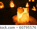 Candle light in ice and snow on Christmas day 60795576