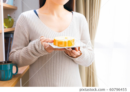 Woman eating sweets roll cake 60796455