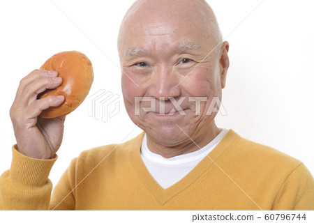 Senior eating anpan with a smile 60796744