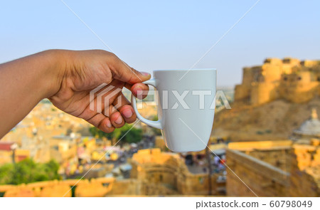 Hand holding a white cup 60798049