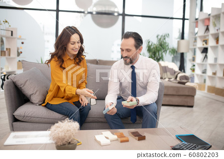 Customer in yellow shirt discussing buying with consultatnt Customer in yellow shirt discussing buying with consultatnt 60802203