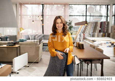 Long-haired pretty woman standing near the armchair Long-haired pretty woman standing near the armchair 60802403