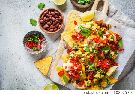 Nachos chips with cheese sauce, guacomole, salsa 60802579