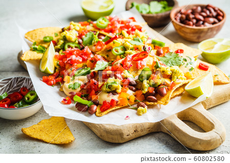 Nachos chips with cheese sauce, guacomole, salsa 60802580