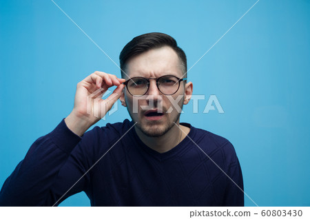 Poorly seeing young man with glasses Poorly seeing young man with glasses 60803430