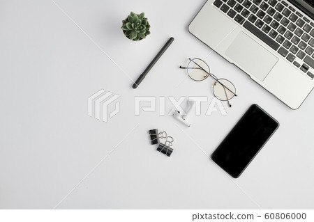 Wireless earphones, eyeglasses, pen, clips, smartphone, small plant and laptop Wireless earphones, eyeglasses, pen, clips, smartphone, small plant and laptop 60806000