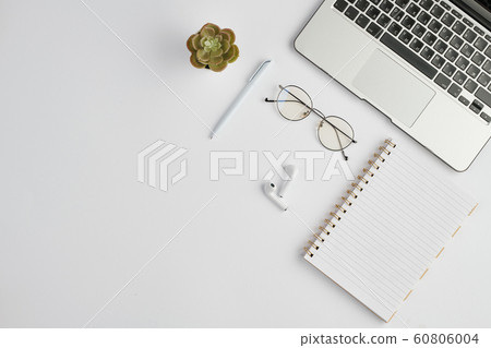 Earphones, eyeglasses, pen, notebook, small domestic plant and laptop keypad Earphones, eyeglasses, pen, notebook, small domestic plant and laptop keypad 60806004
