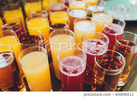 Glasses of fresh juice on an old wooden table. Glasses of fresh juice on an old wooden table. 60806012