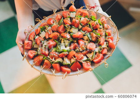 Close-up big plate with serving snack canapes fried bread tomato parsley and salami. 60806074