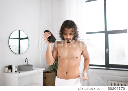 Energetic guy with portable wireless bluetooth speaker dancing in bathroom Energetic guy with portable wireless bluetooth speaker dancing in bathroom 60806170