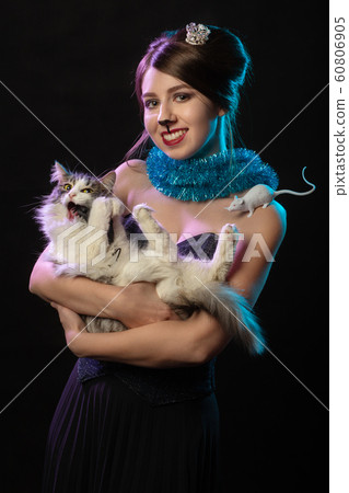 happy girl with Mouse Queen makeup hugs cat on black background looking at camera, smiling 60806905