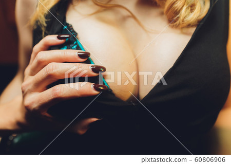 Decollete, female breast. Neckline green dress and fur collar. 60806906