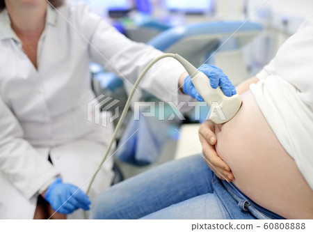 Doctor performing ultrasound on pregnant woman on 60808888