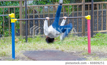 Child going uphill with a horizontal bar in the park 60809251