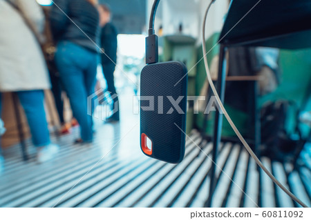Powerbank battery in gray color charging devise through black USB cable on table Powerbank battery in gray color charging devise through black USB cable on table 60811092