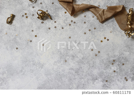 New Year festive composition, web banner with black and gold confetti stars and silk ribbbon. Party decoration, celebration concept. Flat lay, top view. Grunge concrete background. Empty copy space. 60811178