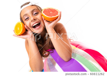 happy girl with orange and grapefruit leans on an inflatable swimming ball on a white background happy girl with orange and grapefruit leans on an inflatable swimming ball on a white background 60811262