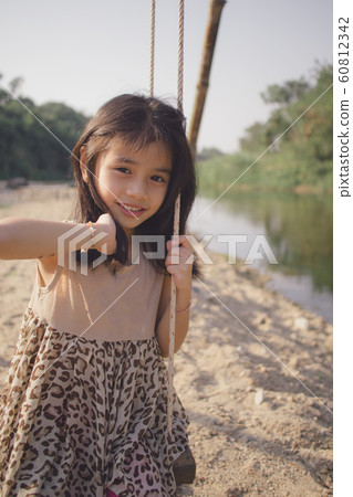 little girl sitting on a swing 60812342