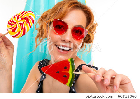 portrait of a sunny retro girl with lollipops on the background of a surfboard 60813066